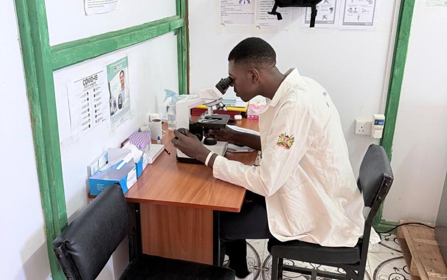 Lab technician examining a sample under the microscope